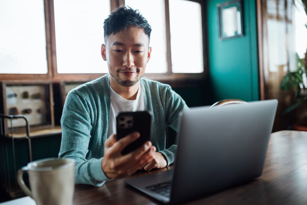 A man smiling at his phone