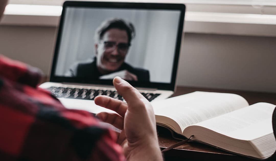 A man video calling on his laptop