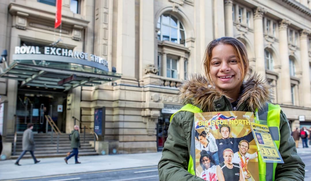 A woman smiling with big issue