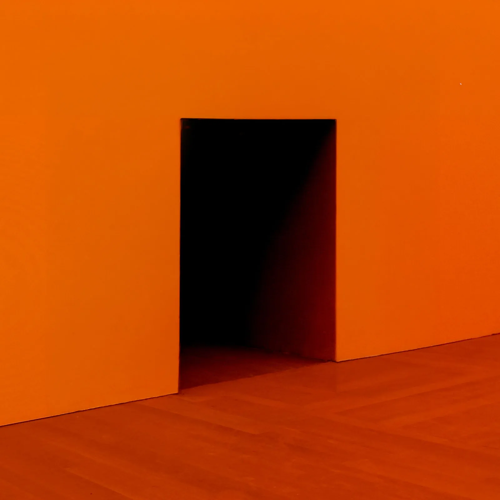 A square-shaped hole in an orange wall.