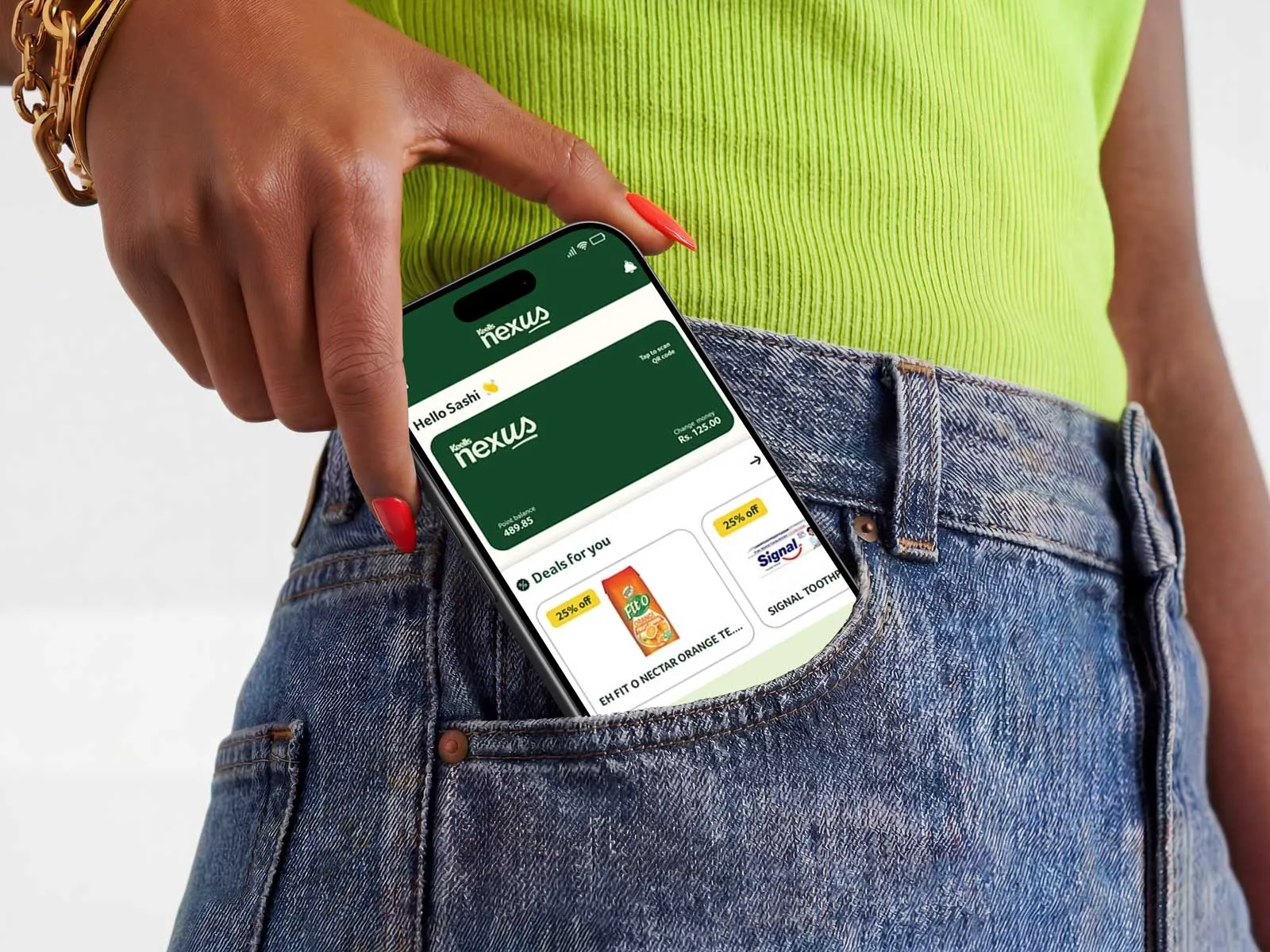 A mobile peeks out of a woman's jean's pocket, displaying the Keells Nexus app
