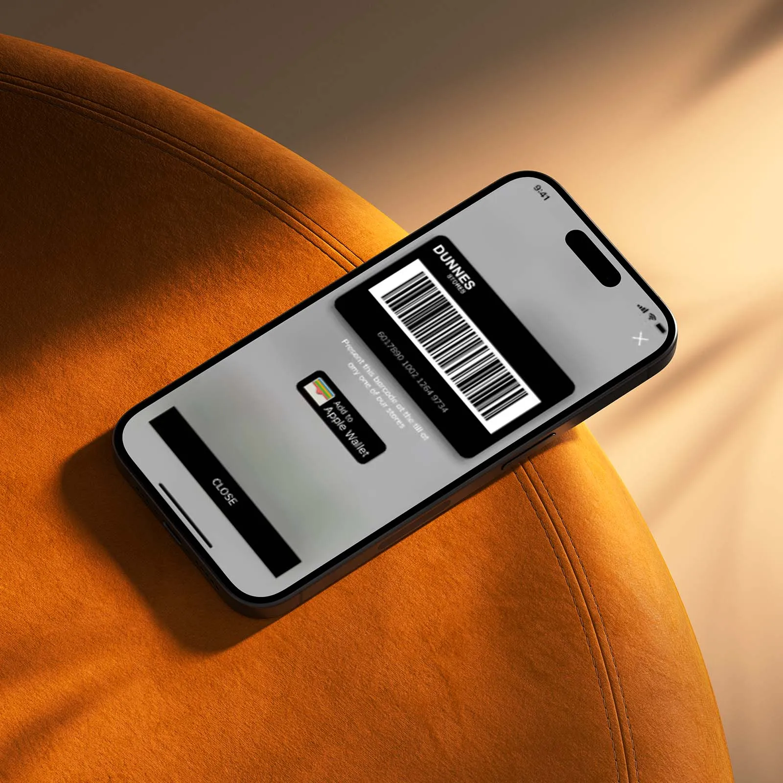 A mobile phone displaying the Dunnes Stores Valueclub app, resting on an orange stool.