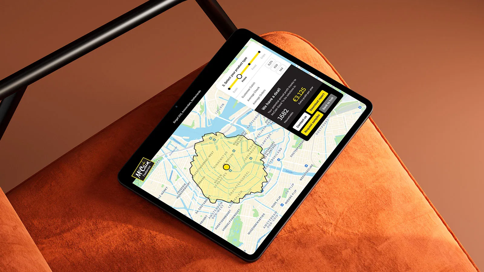 iPad displaying the McCain B2B app, balanced on an orange chair with black armrests