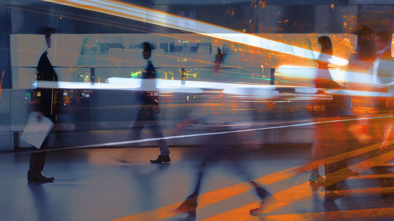Blurred businesspeople walking through a modern office, overlaid with streaks of orange and white light.