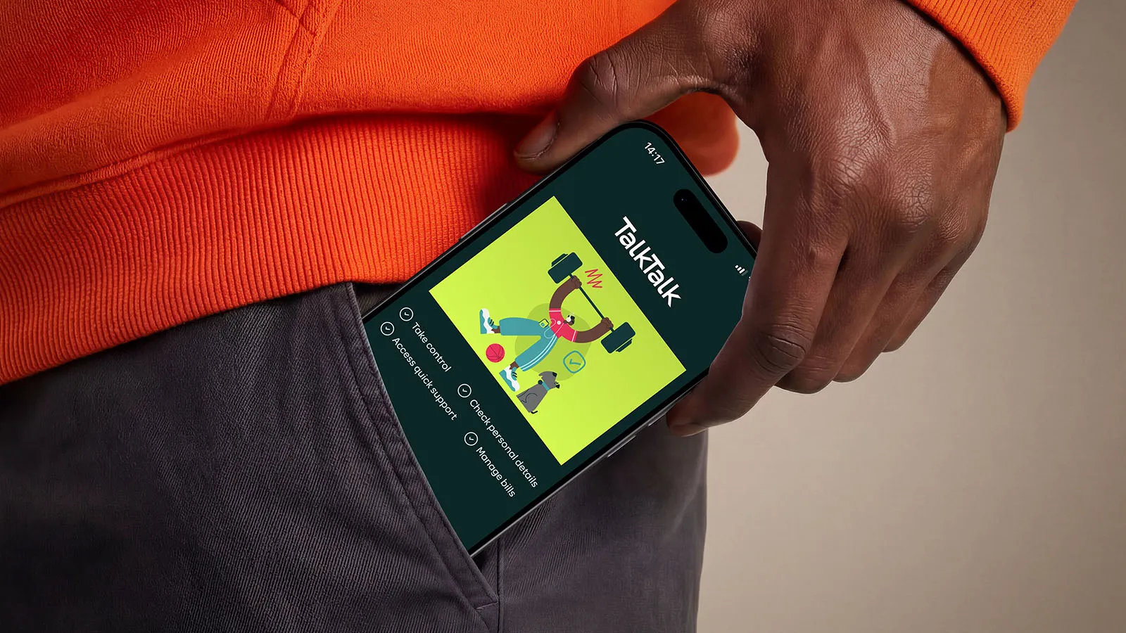 Close-up of a hand holding a smartphone displaying the TalkTalk app’s colorful illustration, against an orange sweater and dark pants.